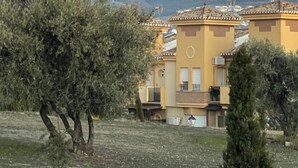 A residential area with buildings, trees, and a mountain range in the background. - Casa Rural Lomalinda: Mountain Views, Wi-Fi, and Air Conditioning (Granada)