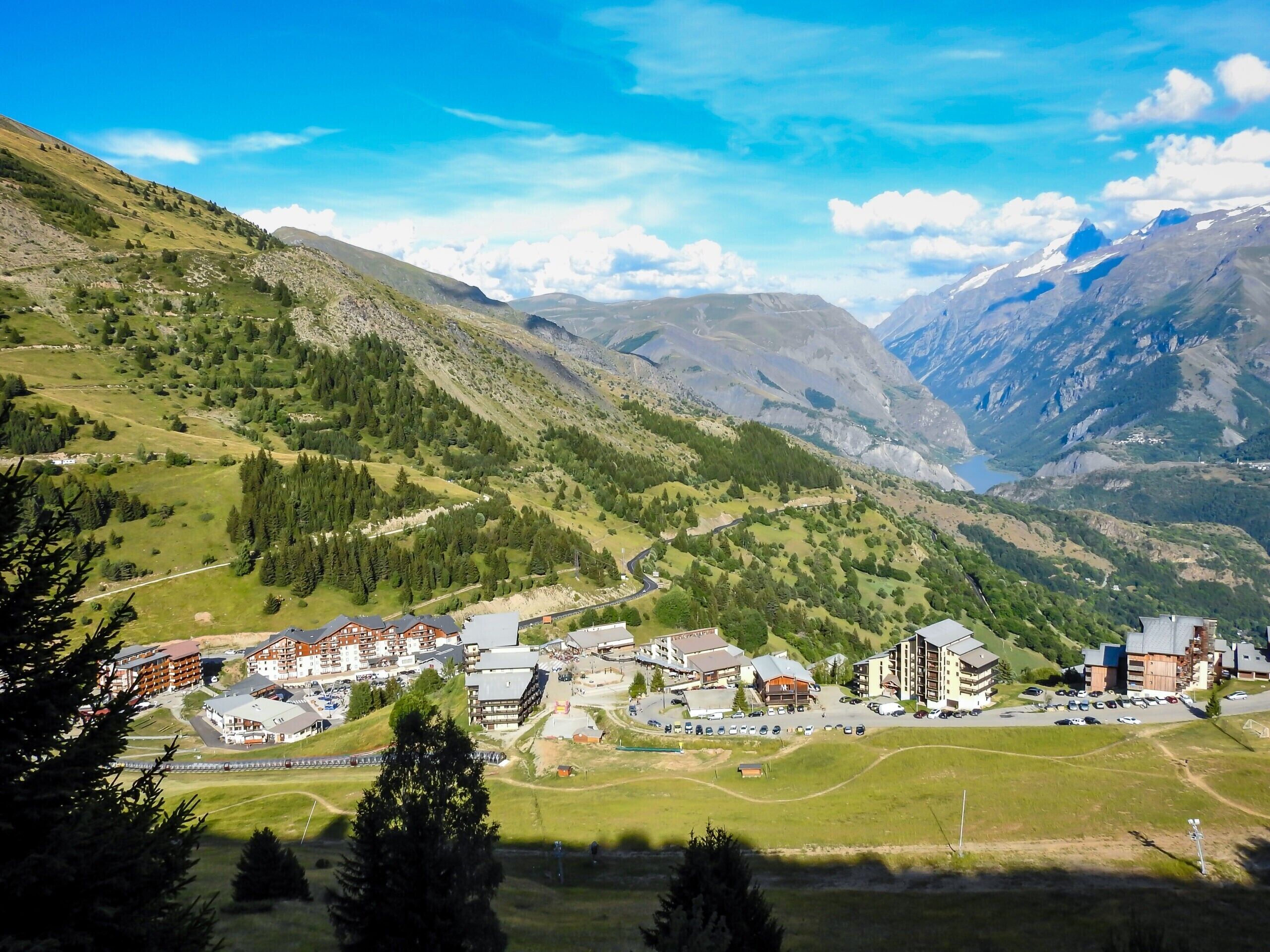 A mountainous town with buildings, roads, and greenery.