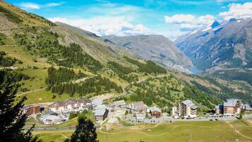A mountainous town with buildings, roads, and greenery.