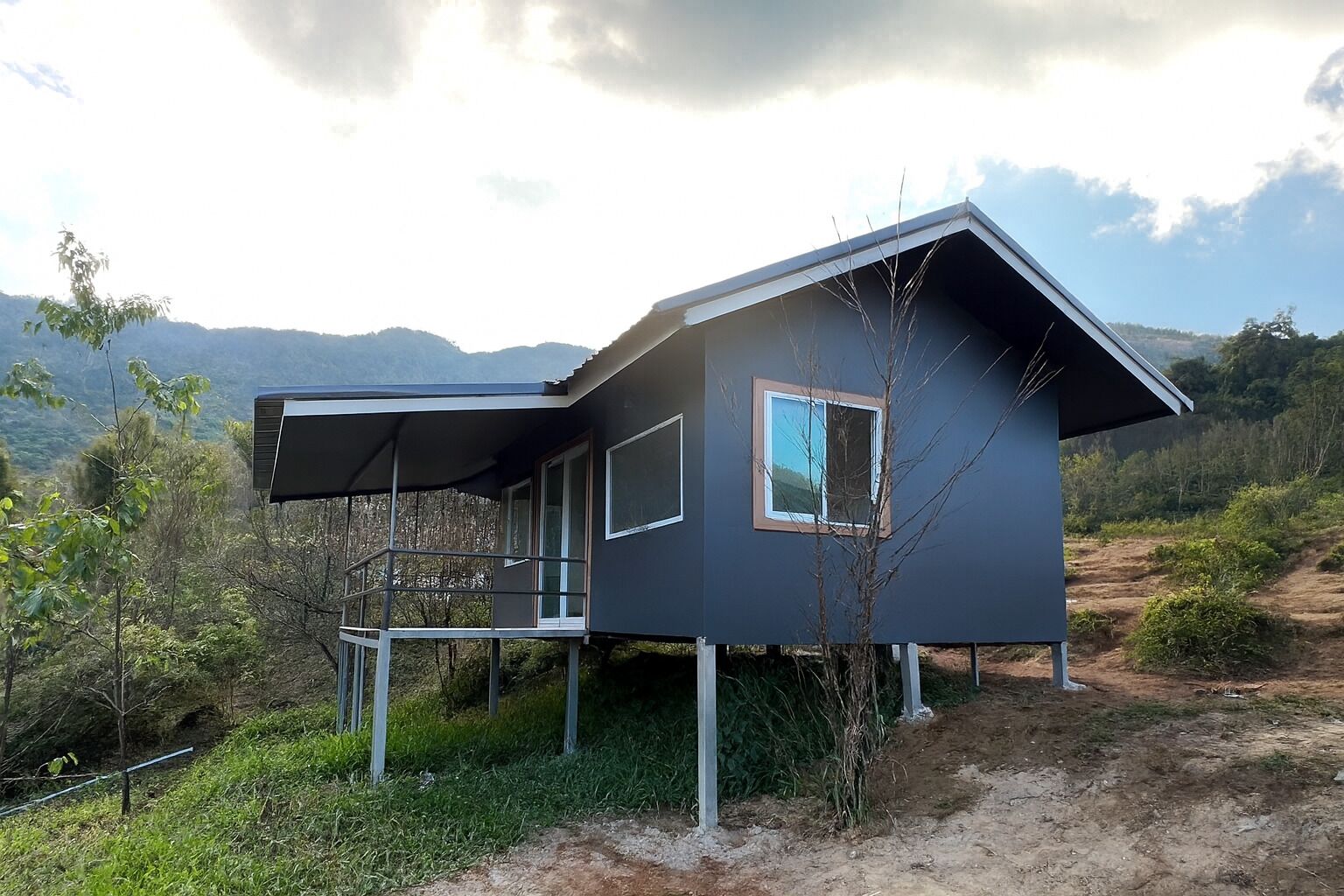 A modern house with a balcony, a window, and a view of the surrounding landscape.
