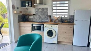 Une cuisine compacte équipée d’un lave-linge, d’un four à micro-ondes et d’un réfrigérateur.