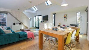 A modern living space with a dining area, sofa, and staircase. - 4 The Stoneyard (Bath)