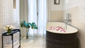 A bathroom with a bathtub, a mirror, a plant, and a tray with flowers and glasses. - GuestHost - In the heart of Brera, in a 20th-century Art Nouveau building on the 1st floor with elevator is the newly renovated double room with large bathroom, a cozy double bed, air conditioning, wifi, mini-bar, coffee maker, smart TV, bath linens, ill (Milan)