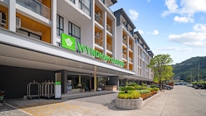 A modern hotel with a green logo, a reception area, and a parking lot. - Beachfront 1524 Wyndham Gardens Condo Naithon (Sa Khu)
