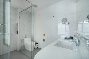 A modern bathroom with a glass shower enclosure, a white toilet, and a large bathtub with a vanity. - Wyndham Garden 1220 Modern Studio Next to Naitho (Sa Khu)