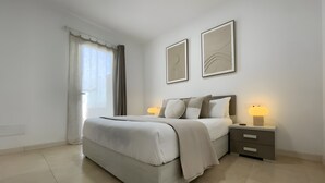 A bedroom with a bed, bedside tables, and two wall-mounted lamps. - Vacation Home 'Lychee' with Private Pool, Wi-Fi and Air Conditioning (Las Palmas)