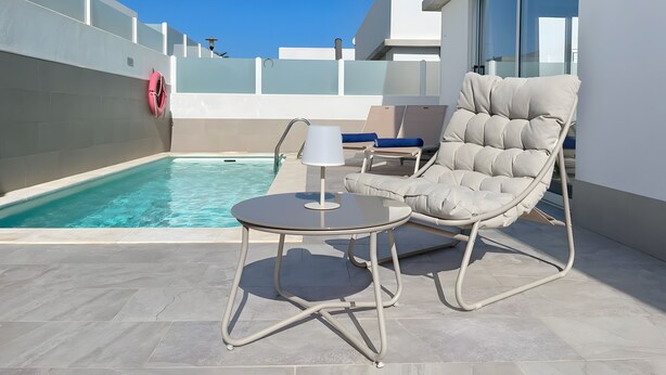 A poolside area with a lounge chair, a small table, and a lamp. - Vacation Home 'Lychee' with Private Pool, Wi-Fi and Air Conditioning (Las Palmas)