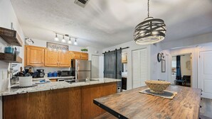 Una cucina con mobili in legno, un'isola grande e un lampadario a sospensione.
