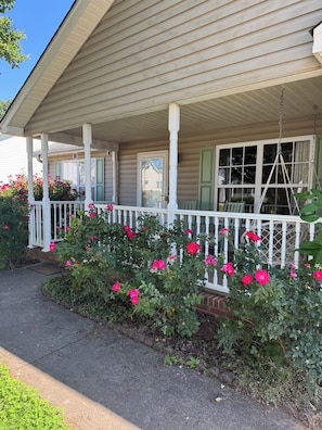 A house with a porch, a number 29 sign, and a swing chair. - Unique Family-Friendly Home with Indoor Playground & Ping Pong! Central Location (Greenville)