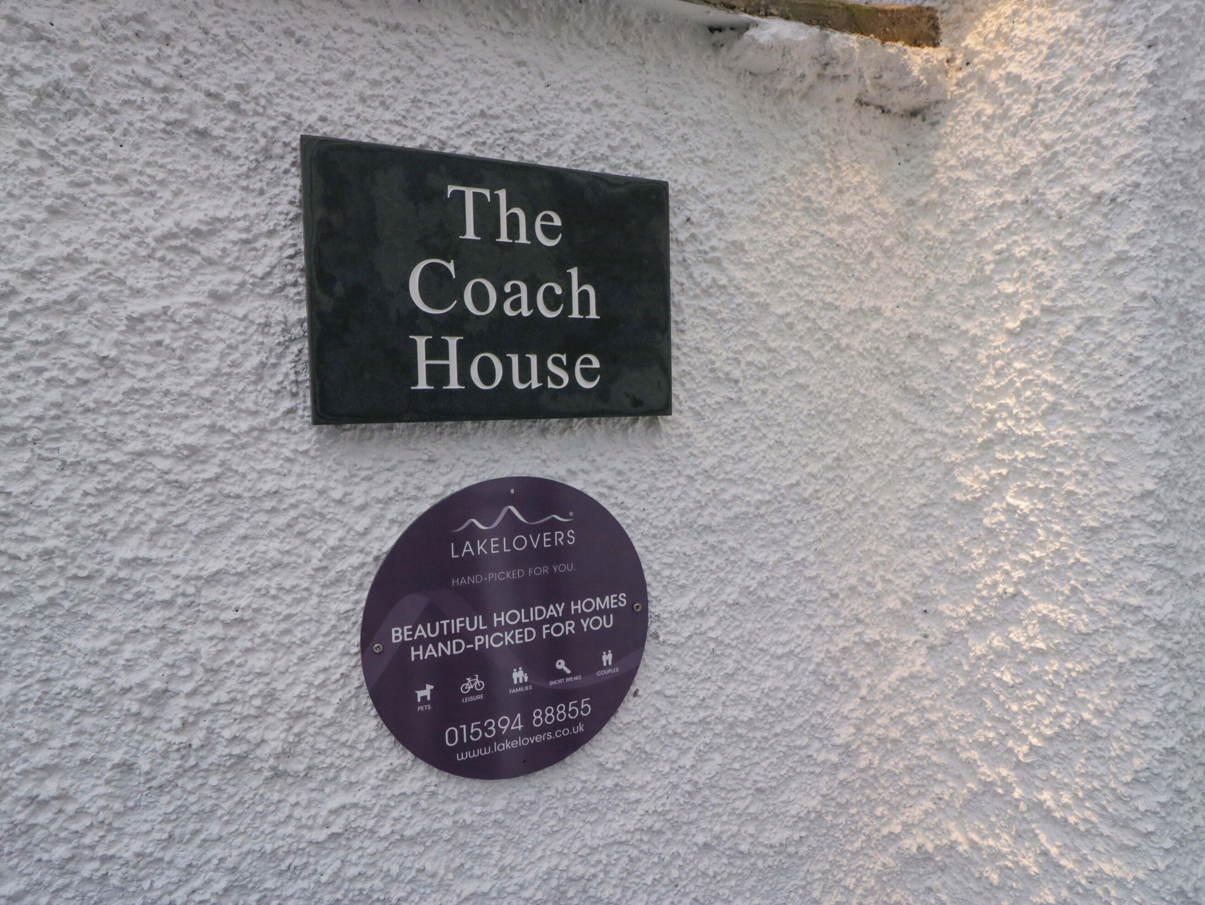 A sign for 'The Coach House' and a circular sign for 'LAKELOVERS' with contact information.