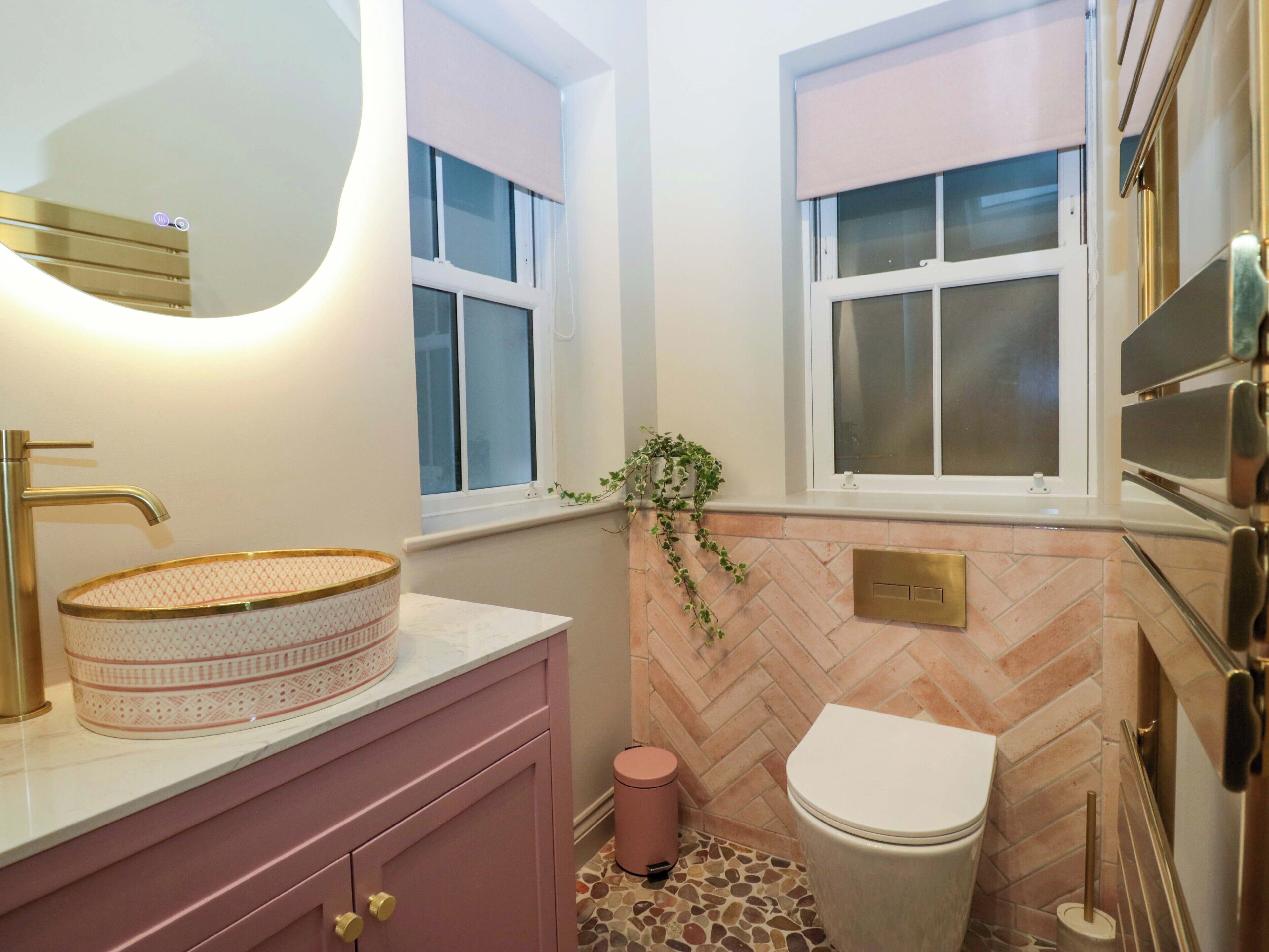 Un baño con lavamanos redondo, inodoro y ventana con vistas.