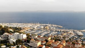 A marina with boats, a Ferris wheel, and buildings with red roofs.