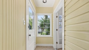 A narrow hallway with a window, a door, and a doorbell. - The Pearl Unit B, Stay for 4 (St. Augustine)