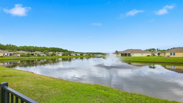A tranquil pond with a fountain in the center, surrounded by well-maintained lawns and residential buildings. - Serenity by the Sea - For 6 (St. Augustine)