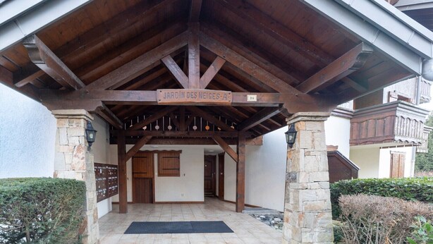 Una entrada cubierta de madera con un letrero que dice 'JARDIN DES NEIGE-A'.