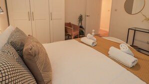 Une chambre d’hôtel comprenant un lit, une chaise, un bureau, un miroir et une armoire.
