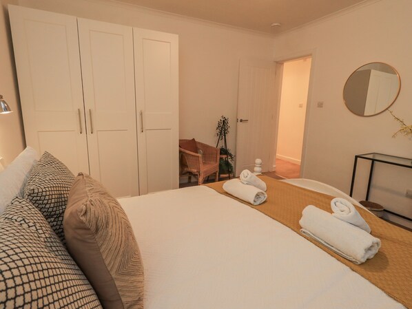 Une chambre d’hôtel comprenant un lit, une chaise, un bureau, un miroir et une armoire.