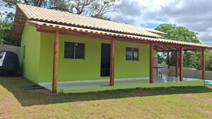 A small, single-story house with a green exterior and a tiled roof. - Esmeraldas Garden Site, a peaceful place with a wonderful view and a swimming pool. (Esmeraldas)