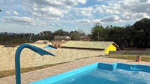 A rectangular swimming pool with a blue interior and a curved edge. - Esmeraldas Garden Site, a peaceful place with a wonderful view and a swimming pool. (Esmeraldas)