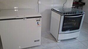 A compact kitchen with a white refrigerator, a glass-top oven, and a tiled floor. - Esmeraldas Garden Site, a peaceful place with a wonderful view and a swimming pool. (Esmeraldas)