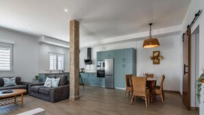 Un espacio habitable moderno con sofá, mesa de comedor y área de cocina.