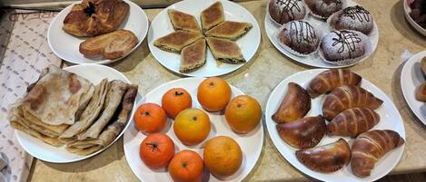 A variety of pastries and fruits on plates.