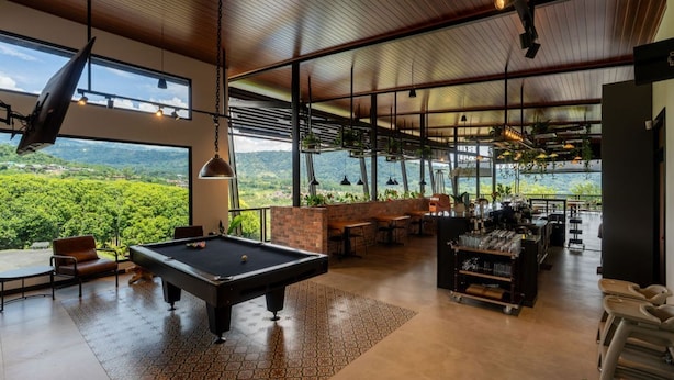 Un grand espace intérieur comprenant une table de billard, des sièges et un coin bar.