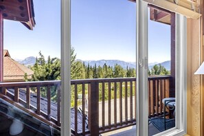 Un balcon avec vue sur les montagnes et les arbres.