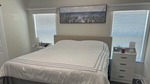 A bedroom with a bed, a nightstand, a dresser, and a painting on the wall. - Perfect 3-bedroom house with AC in Fort Myers Beach (Fort Myers Beach)