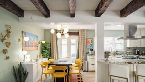 Een moderne keuken met witte kasten, een roestvrijstalen afzuigkap en een groot eiland met barstoelen.