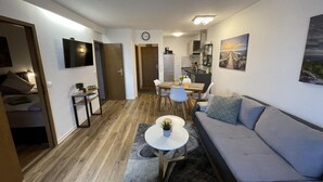 Ein modernes Wohnzimmer mit Sofa, Couchtisch und Essbereich.