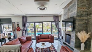 Una sala de estar moderna con un amplio sofá modular, una mesa de centro y una chimenea de piedra.
