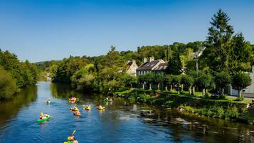 Une rivière où l’on peut faire du kayak, avec des maisons et des arbres sur ses rives.