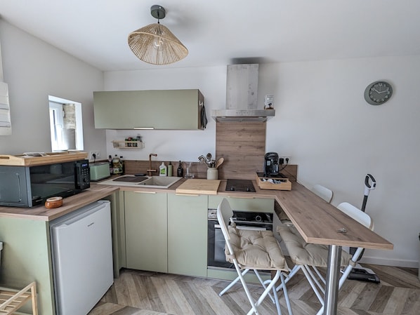A compact kitchen with a microwave, sink, and coffee maker.