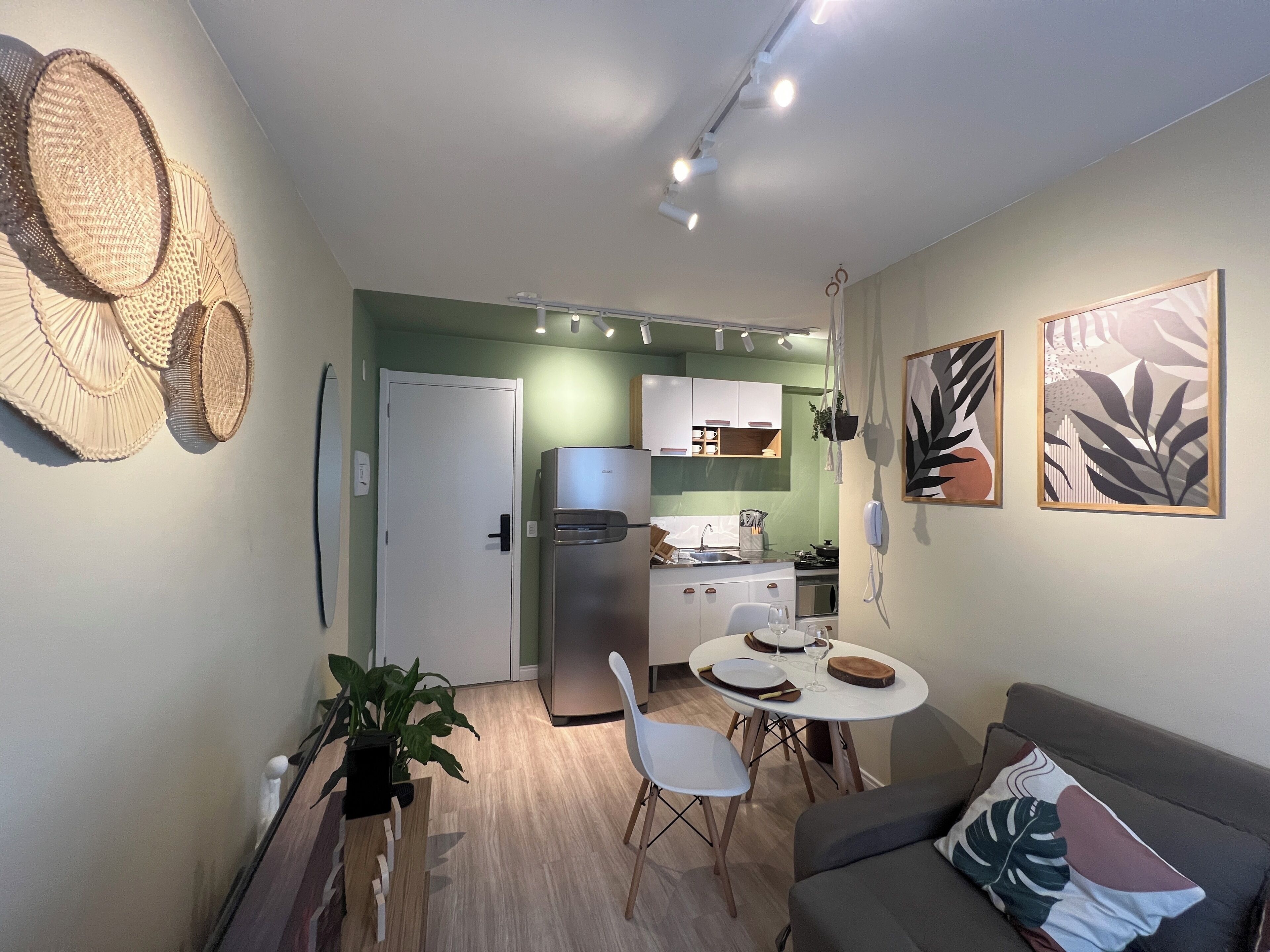 Un espacio habitable compacto con kitchenette, comedor y sofá.