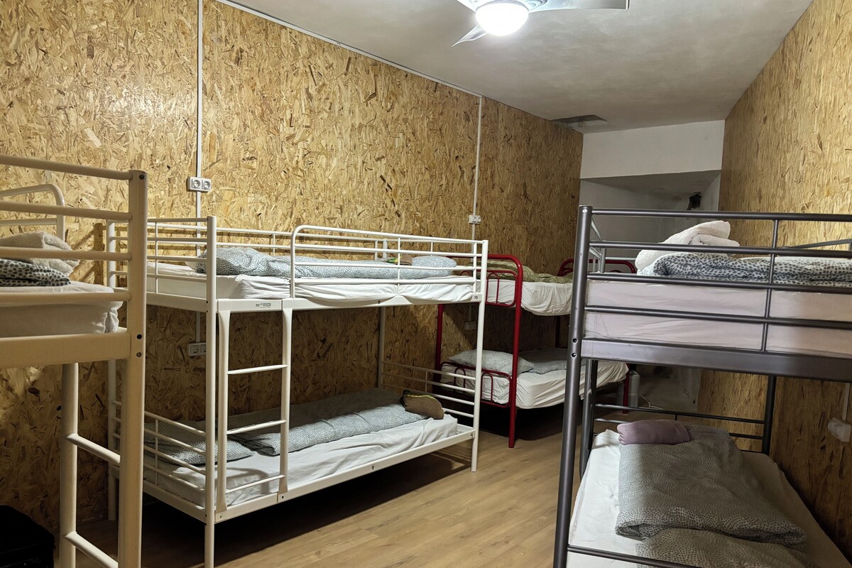 Un dormitorio con literas, paredes de madera y una luz en el techo.