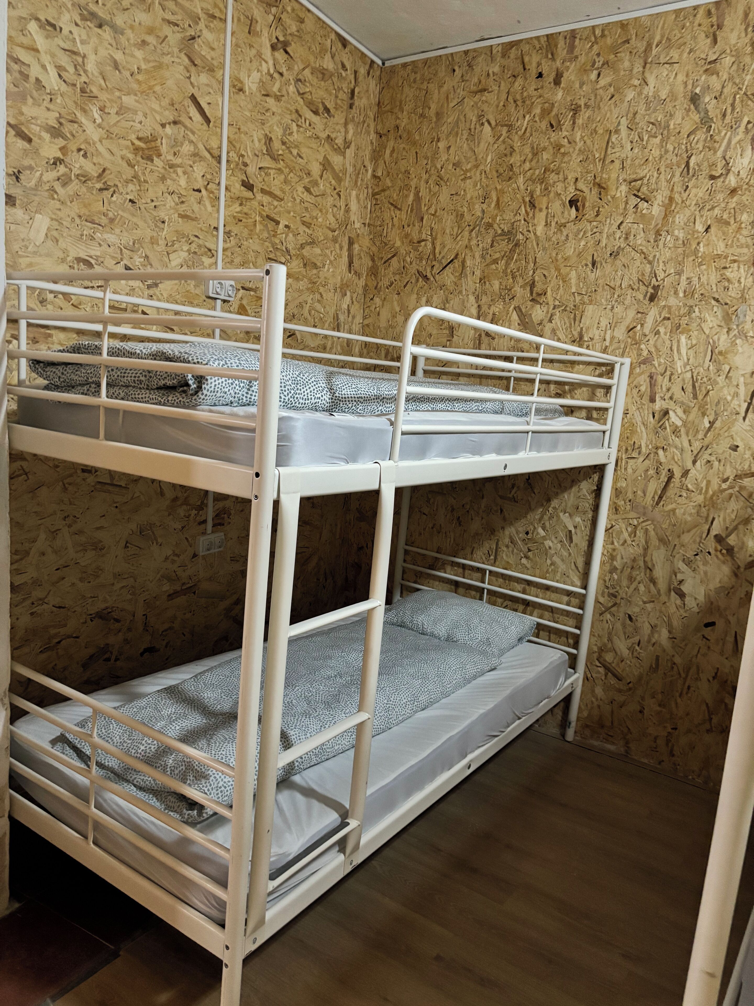 A bunk bed room with wooden walls and a tiled floor.