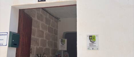 Der Eingang eines Hostels namens "La Geditana" mit einem Schachbrettfußboden und einem Blumentopf.