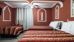 A hotel room with two beds, a ceiling fan, and a window with curtains. - Hotel El Baron (León)