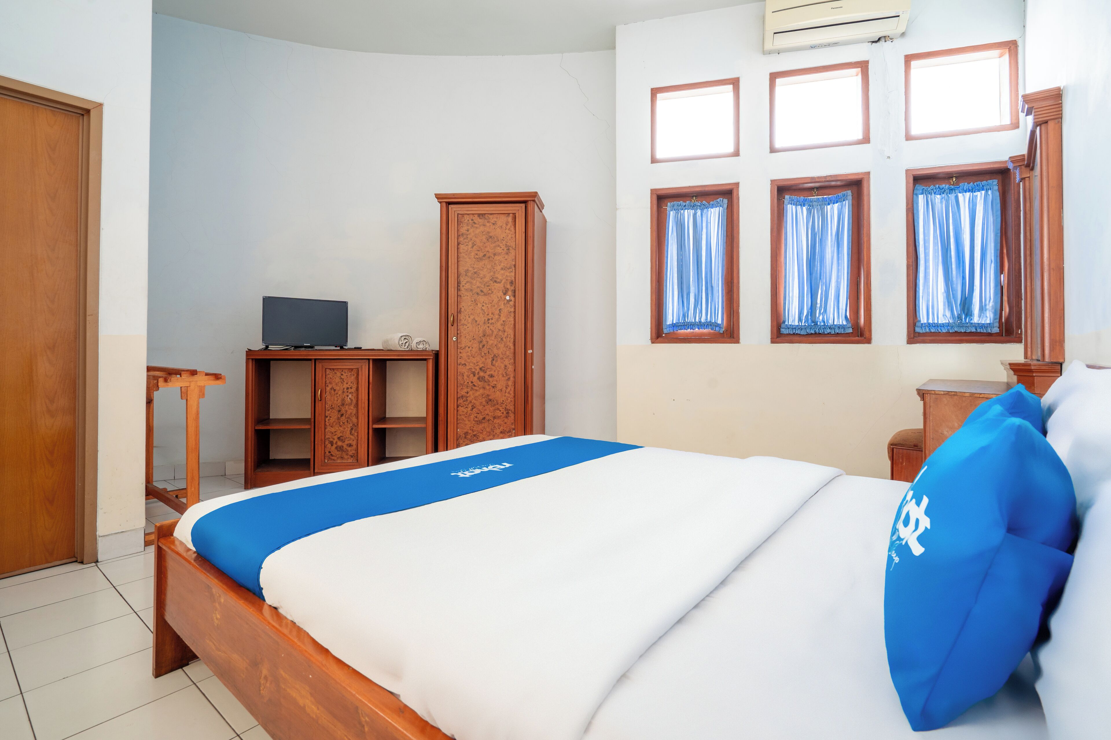 Une chambre bien rangée, avec un lit, un bureau et une armoire.