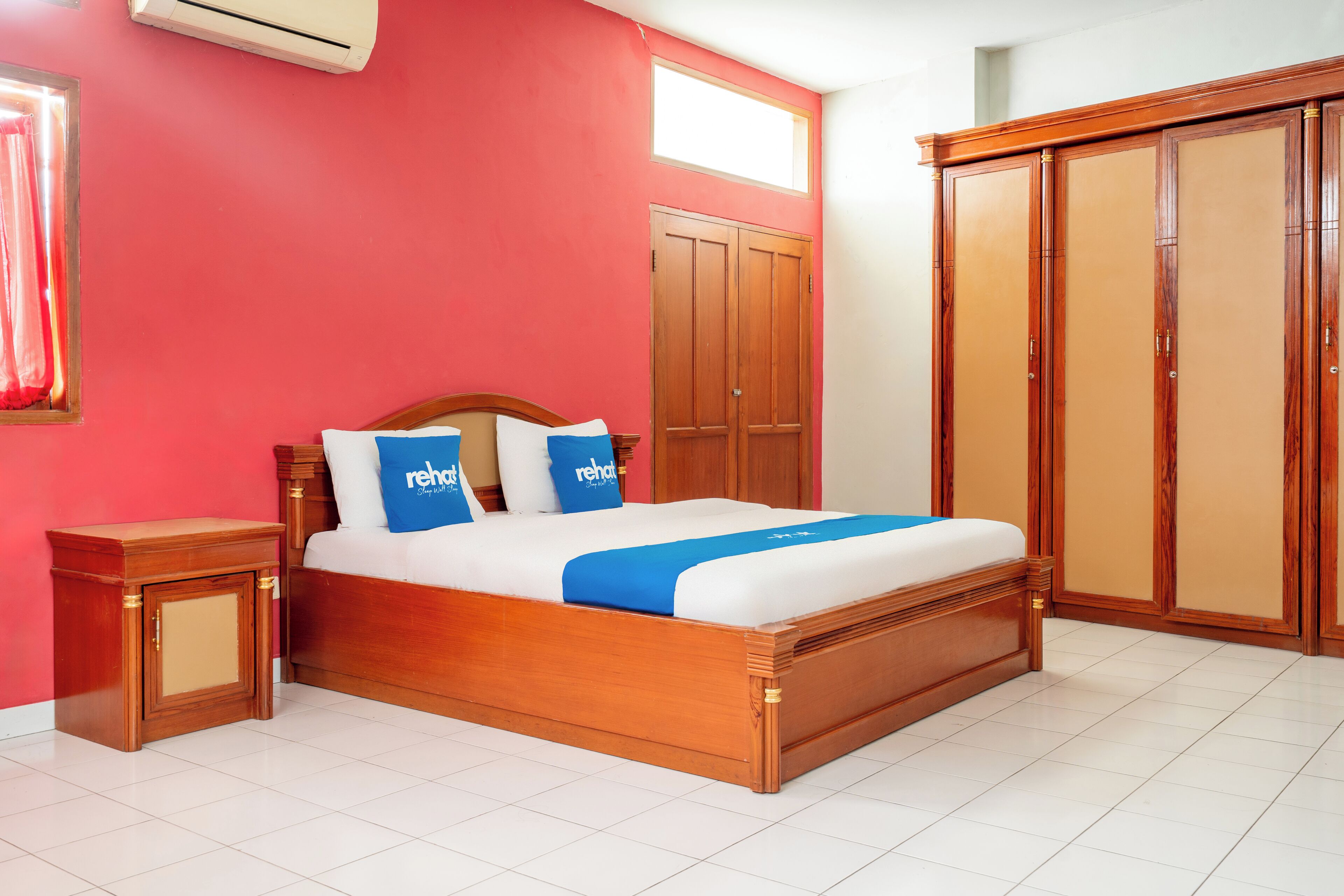 Un dormitorio con una cama de madera, un armario y una mesita de noche.