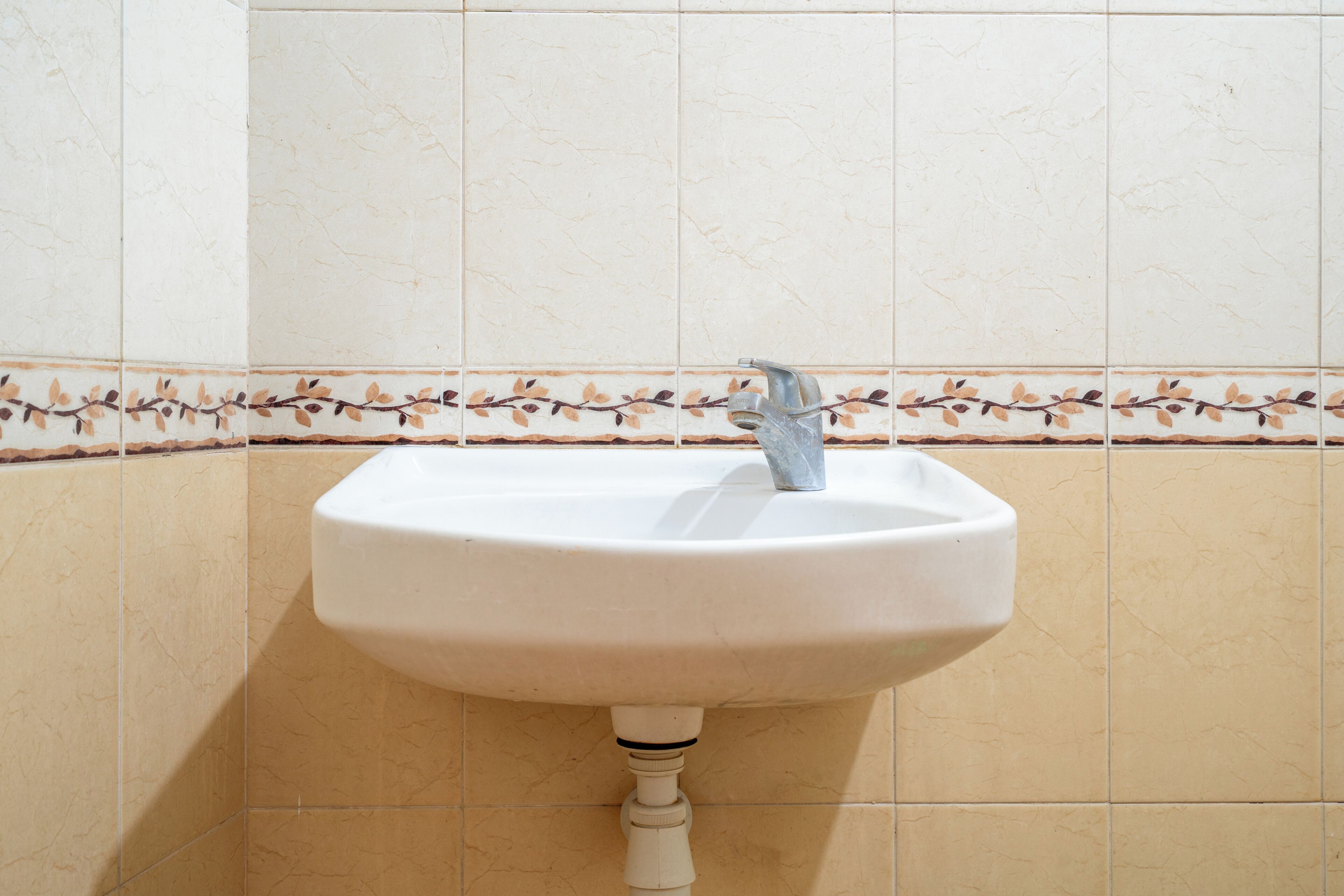 Un lavamanos con lavabo blanco y un solo grifo.