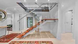Eine moderne Treppe mit Glastrennstäben und Holzbeschlägen, die zu einer oberen Ebene führt.