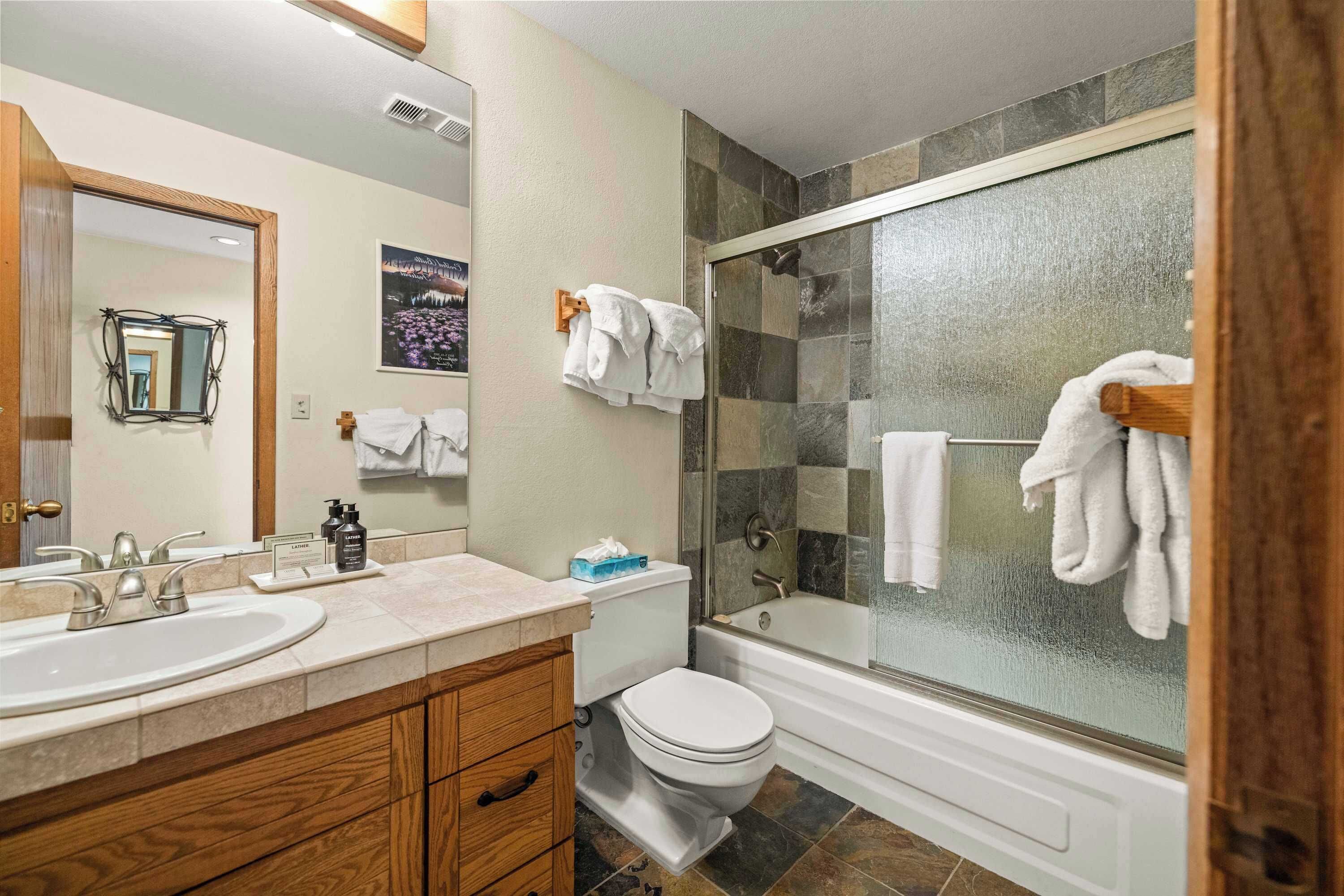 A bathroom with two sinks, a toilet, a bathtub, and a shower with glass doors.
