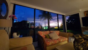 Ein modernes Wohnzimmer mit großem Fenster, einer Couch und einem Couchtisch.