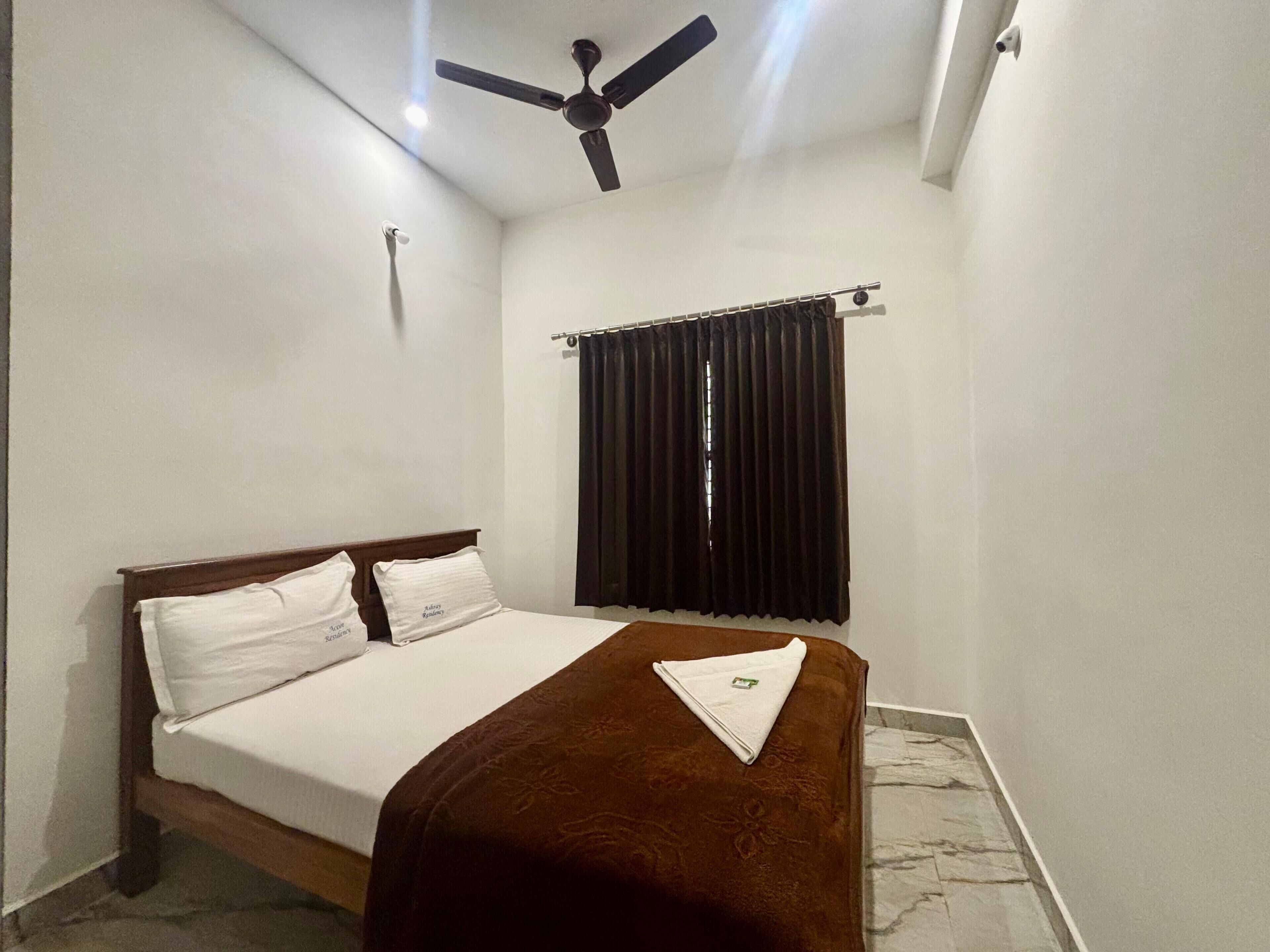 A bedroom with a bed, a ceiling fan, a window with curtains, and a marble floor.
