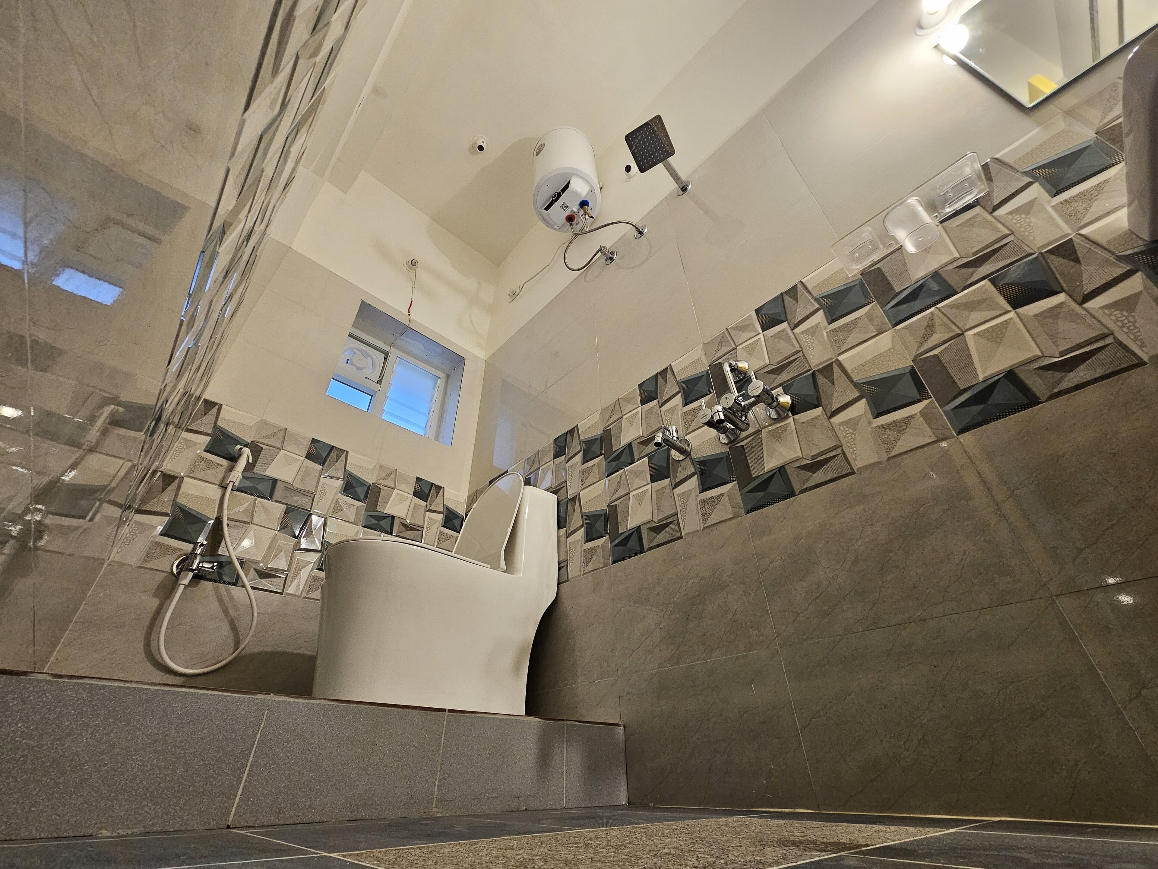 Ein modernes Badezimmer mit Toilette, Dusche und einem Fenster.
