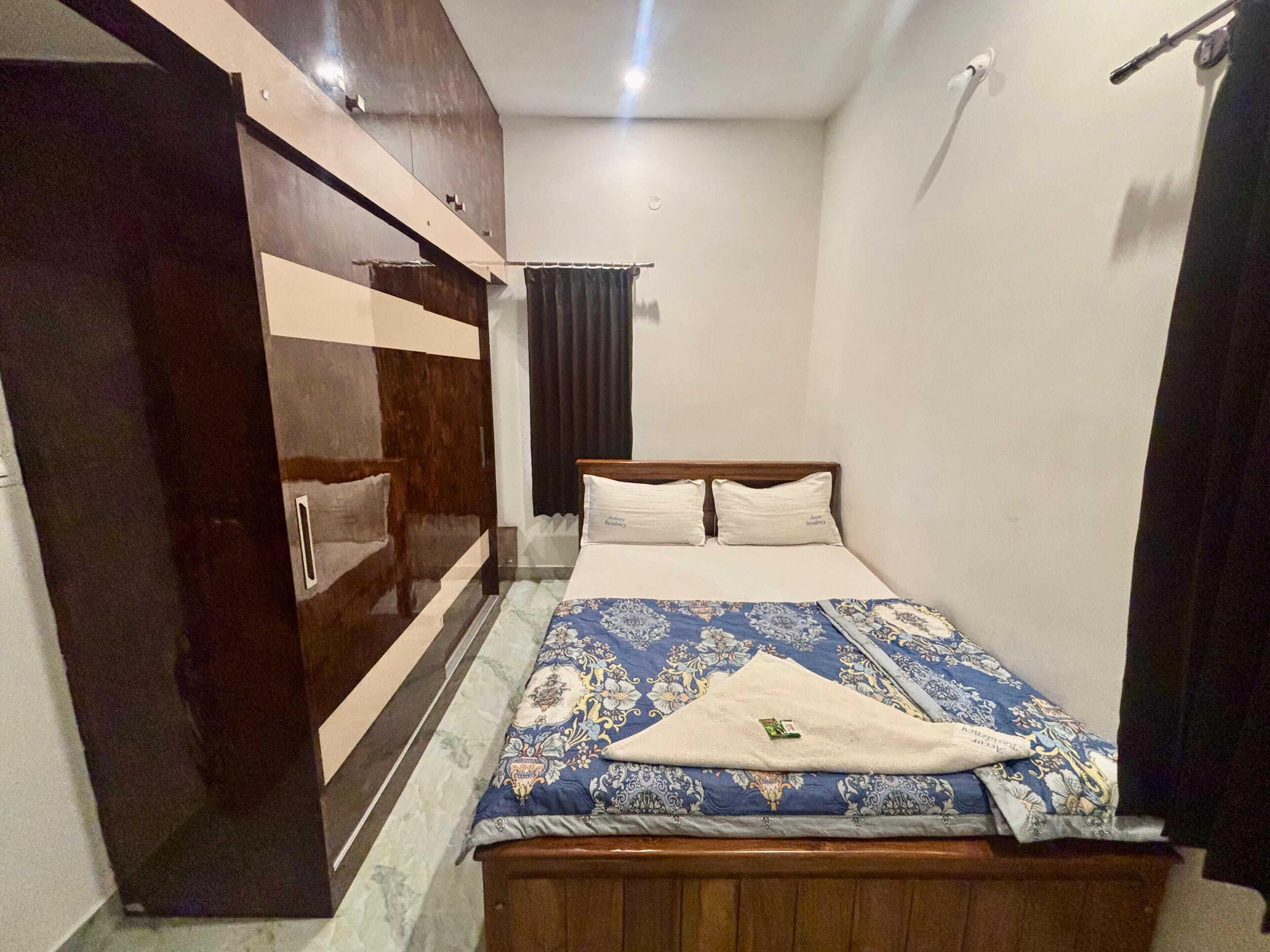 A bedroom with a bed, a wardrobe, and a curtain.