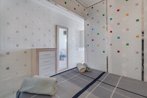 Una stanza con un letto, un armadio e uno specchio.