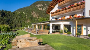 Un hôtel doté d’un balcon en bois, de sièges en plein air et offrant une vue sur les montagnes.